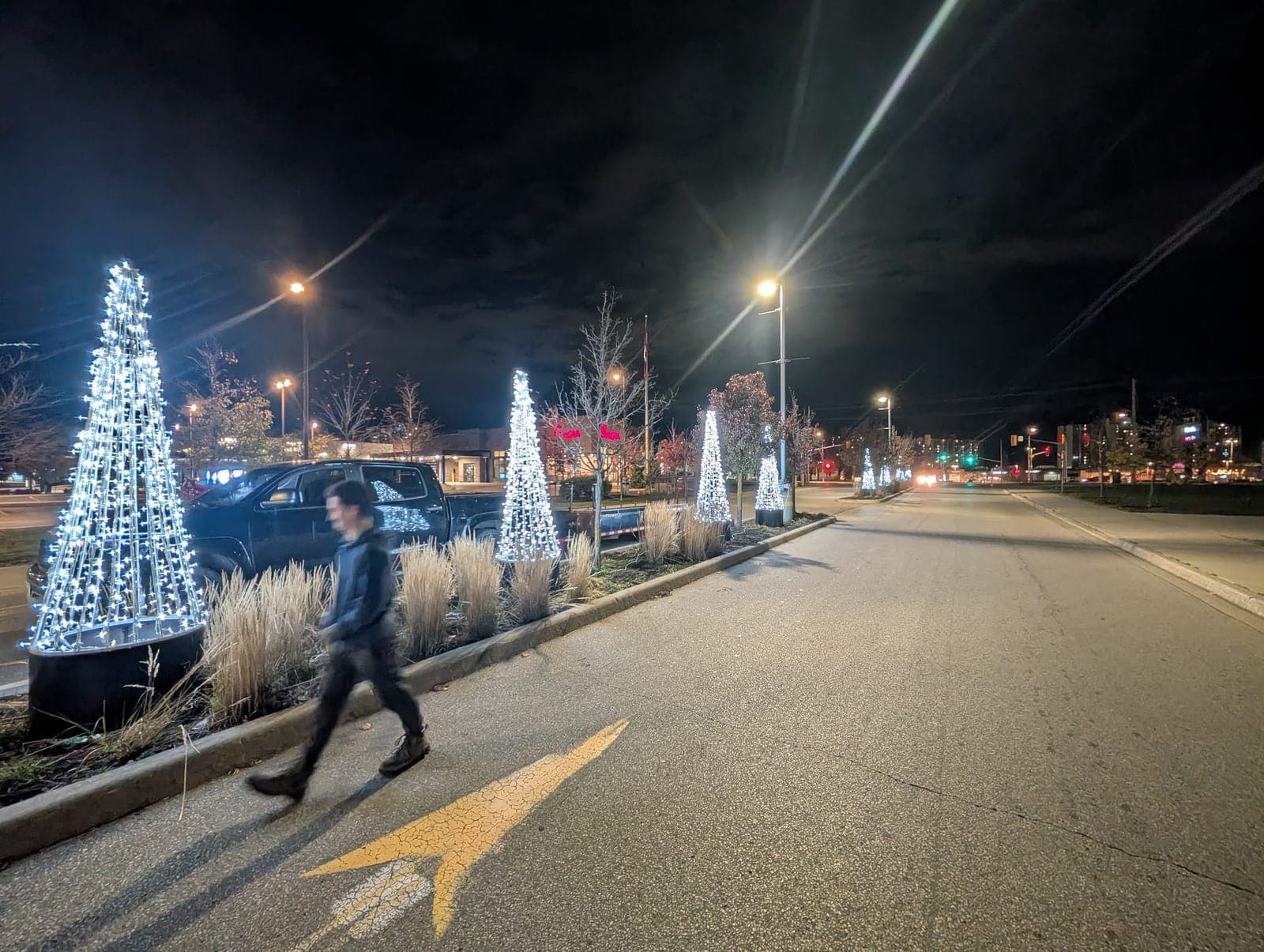 Facility crew checking an outdoor power distribution box feeding a large commercial Christmas lighting display at night
