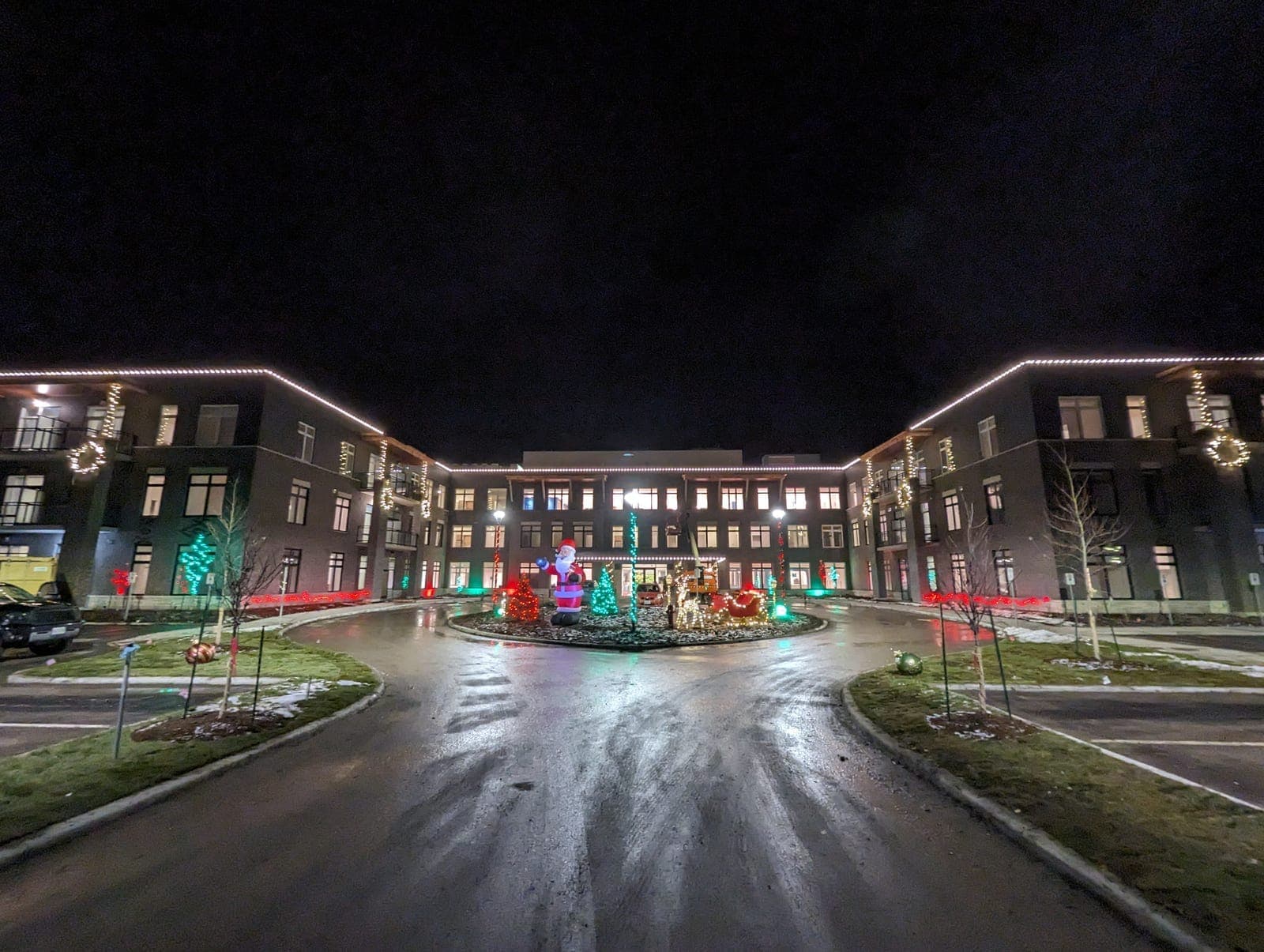 Commercial building roofline outlined in warm white C9 LED bulbs on socket wire at 12-inch spacing in winter dusk