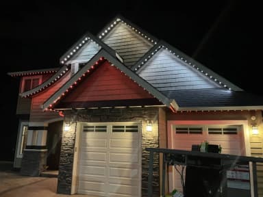 Permanent LED lights in red and white on a home at night